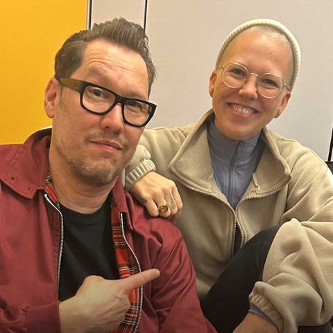 Musik Klub Schweiz mit Stefanie Heinzmann und Jochen Stöckle auf einem gestreiften Sofa im SWR1 Radio Studio