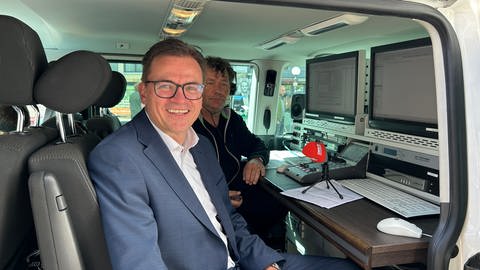 Landrat Joachim Bläse im Reportagewagen vom SWR beim Einsprechen von den Haltestellen für den Stadtbus in Aalen.