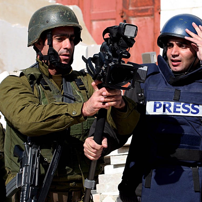 Ein Kamermann mit einem israelischen Militär im Gespräch.