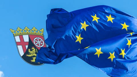 Eine wehende Europaflagge und ein Rheinland-Pfalz Wappen