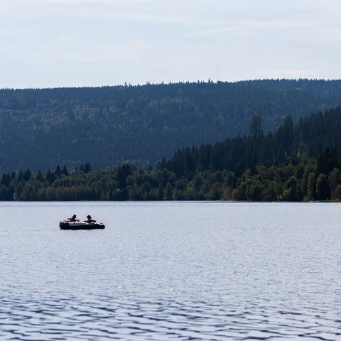 Zwei Menschen schwimmen mit einem Schlauchboot auf dem Schluchsee.