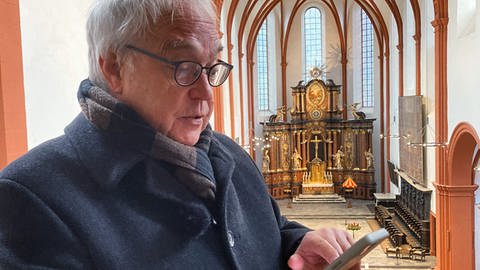 Hermann Lewen hat viele Orgeln in der Region bereits digital hinterlegt. Mit seinem Handy ruft er die Website auf, um die Orgelmusik abspielen zu lassen.