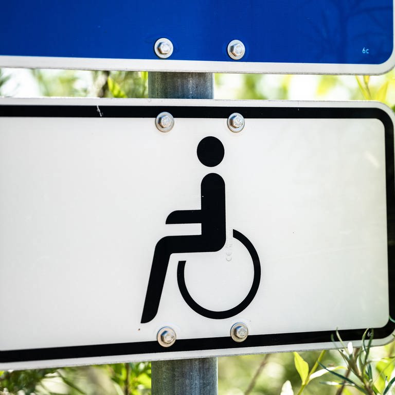 Ein Hinweisschild mit einem Rollstuhl zum Parken für Menschen mit Behinderung