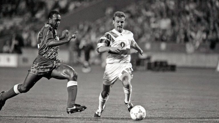 September 1992: Der VfB Stuttgart gewinnt das Hinspiel gegen Leeds United mit 3:0 - darunter zwei Tore von Fritz Walter (r.). Das Rückspiel, welches die Engländer mit 4:1 für sich entscheiden können, wird im Nachhinein von der UEFA mit 3:0 für Leeds United gewertet, nachdem mit der Einwechslung von Jovica Simanic ab der 83. Minute vier statt der erlaubten drei ausländischen Spieler für den VfB auf dem Platz standen. Das zusätzliche Entscheidungsspiel verlieren die Schwaben mit 1:2 und kommen so erneut nicht über die erste Runde hinaus.
