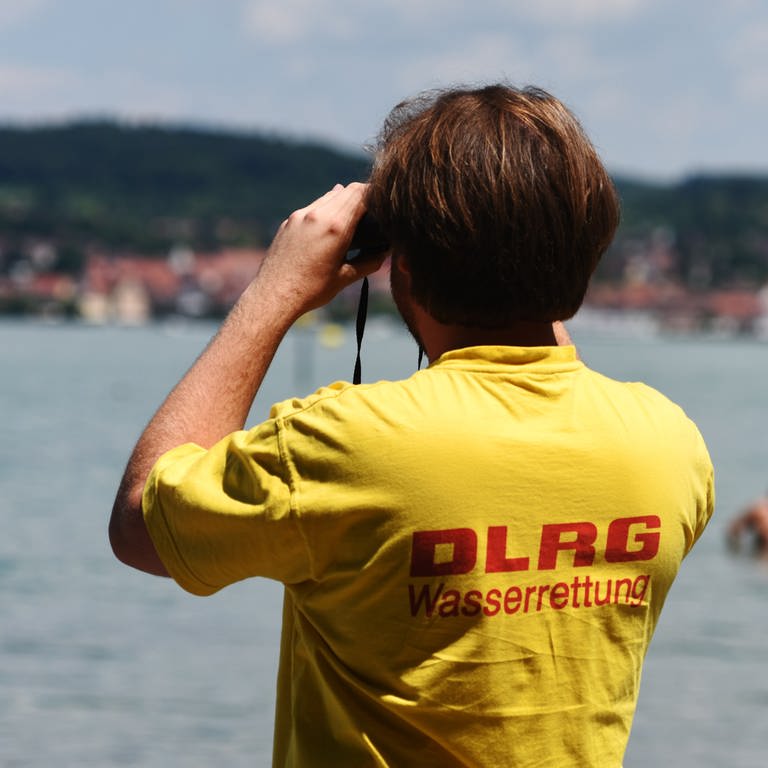 Ein Rettungsschwimmer der Deutschen Lebensrettungsgesellschaft (DLRG) beobachtet bei Wallhausen (Baden-Württemberg) am Strandbad Schwimmer im Bodensee.