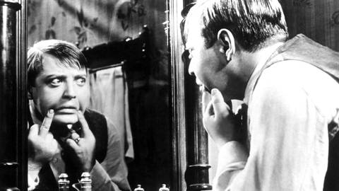 Peter Lorre betrachtet sich selbst im Spiegel