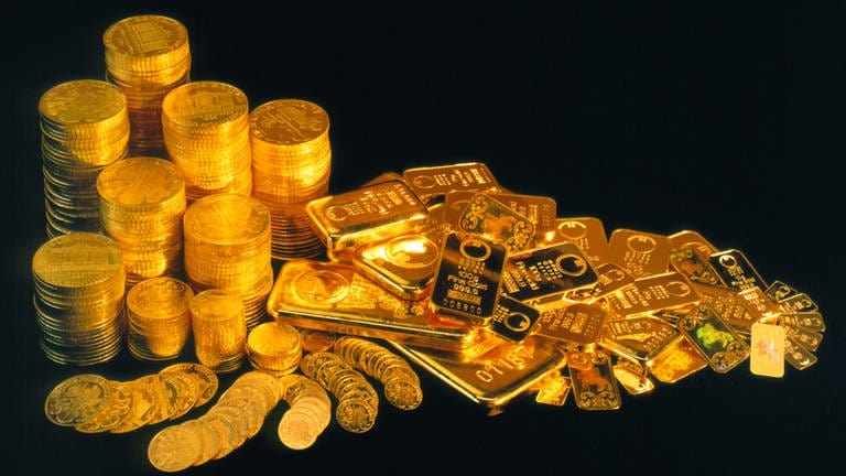 Glänzende Goldbarren und Goldmünzen auf schwarzem Untergrund