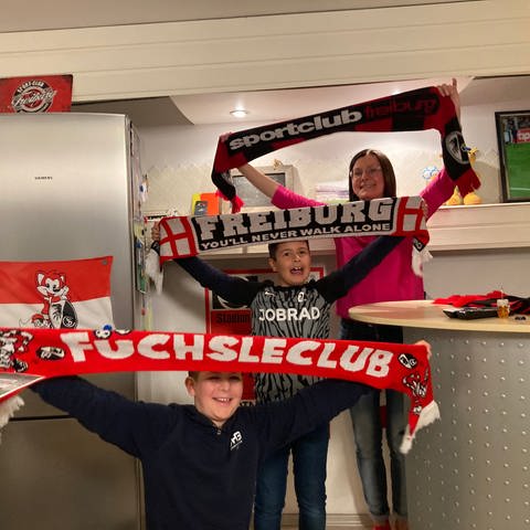 Eine Freiburger Familie mit SC-Fan-Schals. Zum Abschied von Trainer Christian Streich wollen sie eine Party schmeißen.