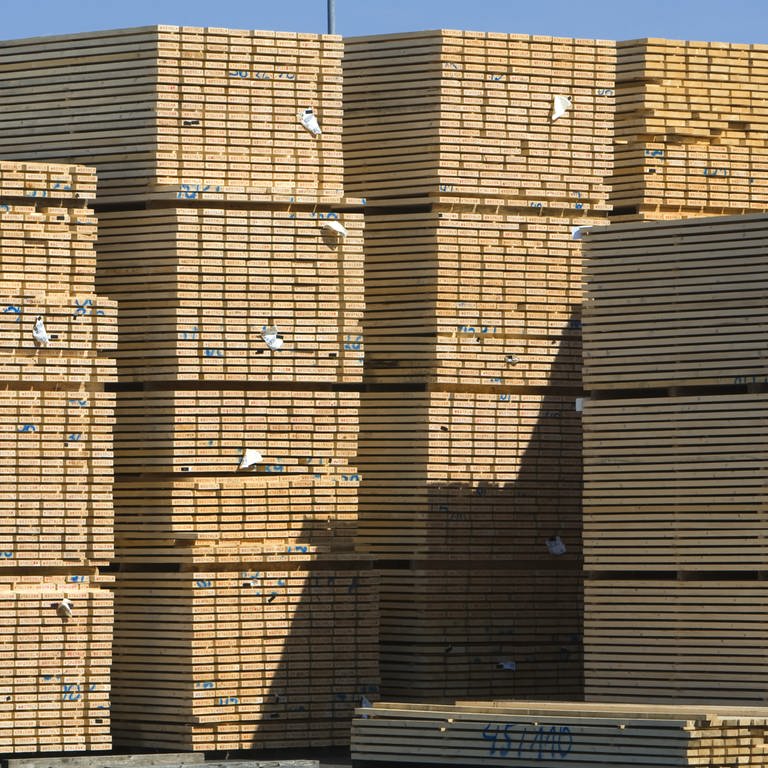 Auf dem Frischholzgelände eines Brettschichtholzwerkes lagern Holzpakete. Die Preise am Holzmarkt sind eingebrochen. (Symbolbild)