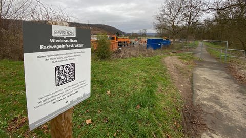 Schilder mit QR-Codes informieren am Radweg in Sinzig über die Fortschritte beim Wiederaufbau.