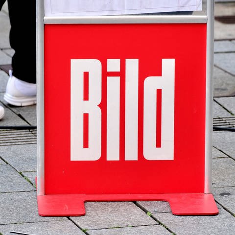 Ein Aufsteller mit dem Logo der "Bild" steht auf einer Straße