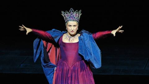 Diana Damrau im purpurnen Gewand mit Krone als drohende Königin der Nacht.