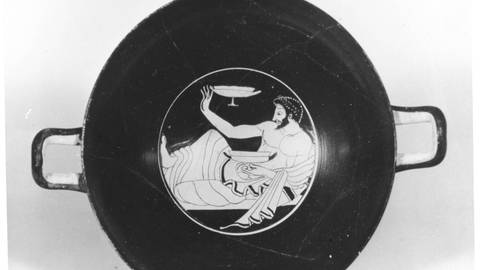 Trinkbecher, ca. 500 v. Chr.: Der abgebildete Mann hält in der linken Hand einen vermutlich mit Wein gefüllten Becher. Mit der Tasse in der rechten Hand spielt er Kottabos.