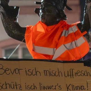 Die Letzte Generation hat in der Nacht zum Weiberdonnerstag bekannte Mainzer Figuren in der Innenstadt mit Warnwesten ud Schildern verkleidet.