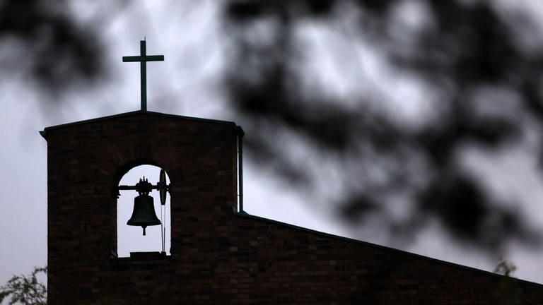 Spitze eines Glockturms mit Kreuz. (Foto: dpa)