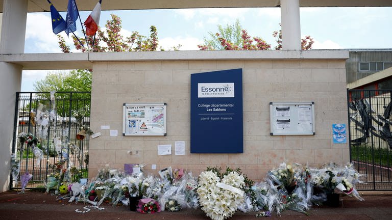 Blumen liegen an einem Schuleingang in Frankreich, wo ein 15-Jähriger von Jugendlichen zu Tode geprügelt wurde.  (Foto: REUTERS)