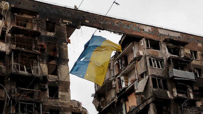 Eine zerrissene ukrainische Flagge hängt an einem Draht vor einem Wohnhaus, das während des ukrainisch-russischen Konflikts in der südlichen Hafenstadt Mariupol (Ukraine) am 14. April 2022 zerstört wurde. (Foto: REUTERS)
