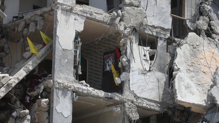  Ein Plakat und Fahnen hängen in einem zerstörten Gebäude im Norden eines Flüchtlingslagers im Gazastreifen (Archivbild). (Foto: dpa)