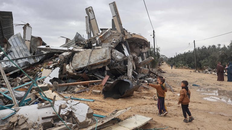 Palästinensische Kinder schauen sich zerstörte Bauwerke in Rafah an