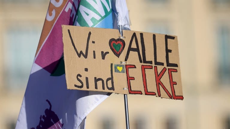 Ein Schild mit der Aufschrift "Wir alle sind Ecke" wird bei einer Demonstration in Berlin wegen Angriffen auf Politiker hochgehalten