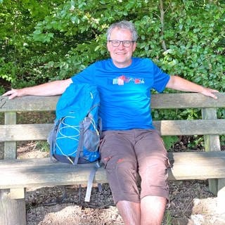 SWR4 Moderator Holger Bentzien sitzt bei einer Rast auf Wanderung, den Rucksack neben sich (Foto: SWR, Holger Bentzien )