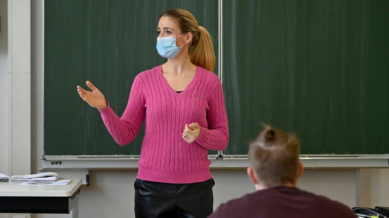 Lehrerin mit Mundschutzmaske im Präsenzunterricht, Corona-Krise, Stuttgart,