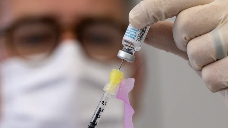 Symbolbild: Ein Klinik-Mitarbeiter bereitet eine Spritze mit einem Impfstoff vor.