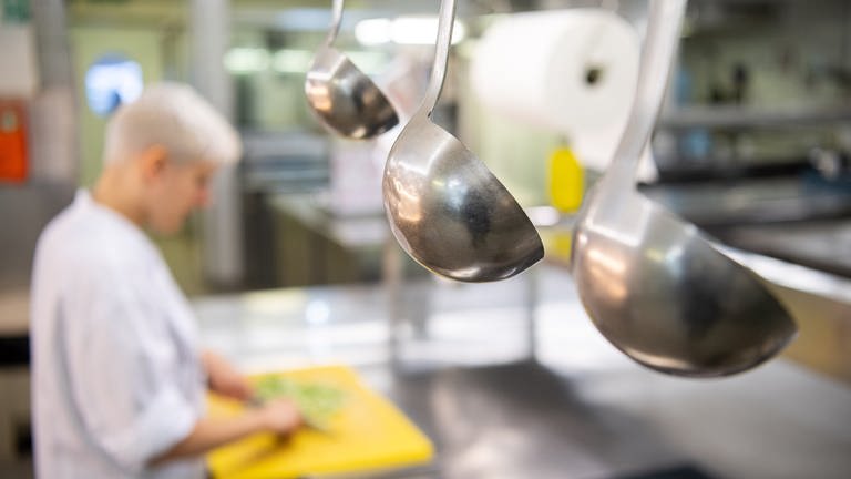 Eine Auszubildende zur Köchin im dritten Lehrjahr arbeitet in einem Hotel in der Küche eines Restaurants. 