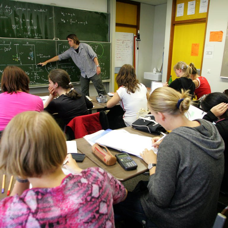 Beim Physikunterricht an einer Freiburger Schule erklärt ein Lehrer seiner Klasse an der Tafel Formeln (Archivbild). 