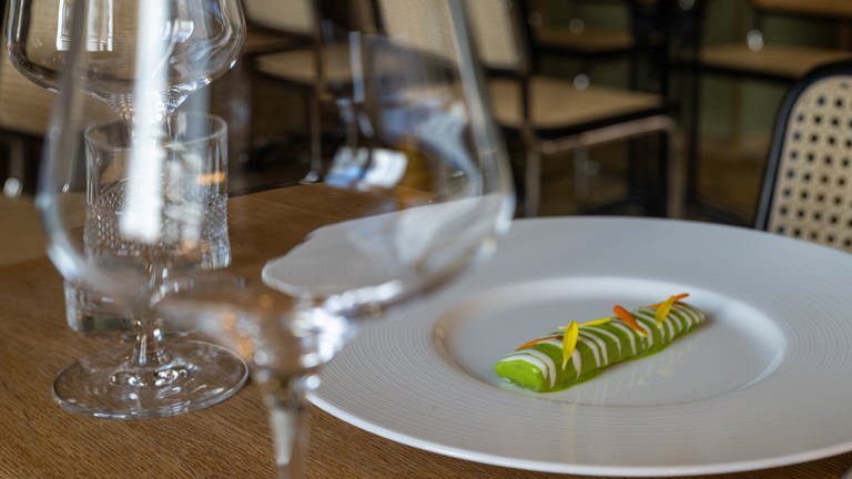 Eine nach Matjesart gebeizte Aubergine liegt im Sternerestaurant "bi:braud" auf einem Teller an einem leeren Tisch. (Foto: dpa Bildfunk, picture alliance/dpa | Stefan Puchner)