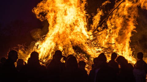 Menschen stehen vor einem brennenden Osterfeuer. (Foto: dpa Bildfunk, picture alliance/dpa/Frank Hammerschmidt (Symbolbild))