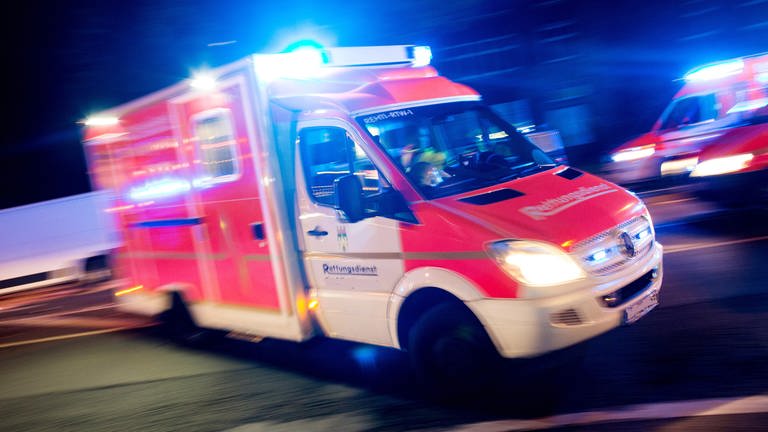 in Rettungswagen der Feuerwehr fährt mit Blaulicht durch eine Straße  (Symbolbild) - Zwei Rettungssanitäter verfolgten einen BMW