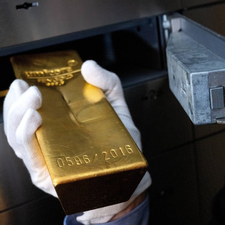 Goldbarren wird in ein Schließfach gelegt (Foto: picture-alliance / Reportdienste, picture alliance/dpa | Sven Hoppe)