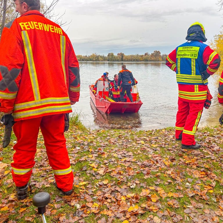 Rettungskräfte an Baggersee, Boot fährt raus, um Leiche zu bergen.