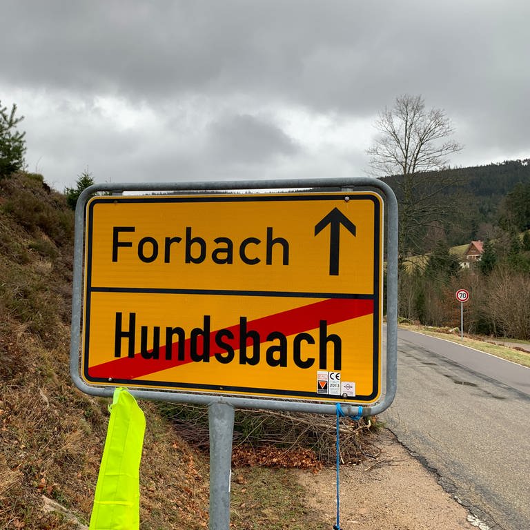 Das Ortsschild im Schwarzwald zeigt den Weg Richtung Forbach, der Ortsname Hundsbach ist durchgestrichen.