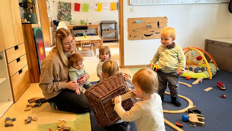 Auszubildende Julia Dolgos spielt in einer Krippengruppe in der Kita Heidezwerge in Karlsruhe mit Kindern. (Foto: SWR)