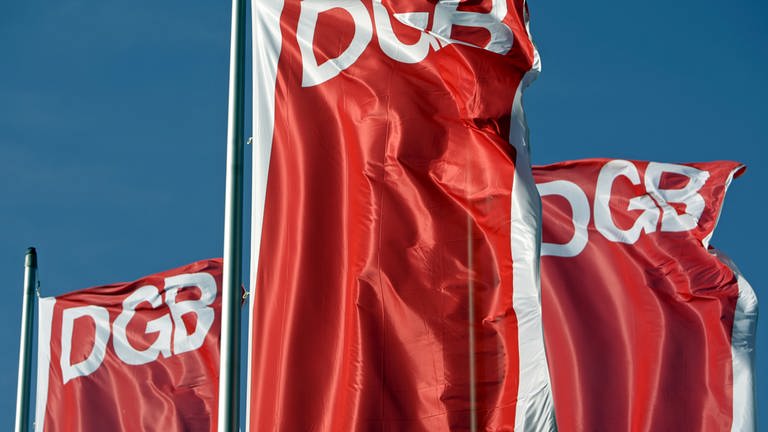 Fahnen des Deutschen Gewerkschaftsbunds (DGB) wehen vor dem blauen Himmel. Der DGB hat am 1. Mai wieder zu Kundgebungen aufgerufen. (Foto: dpa Bildfunk, picture alliance/dpa/dpa-Zentralbild | Jan Woitas)