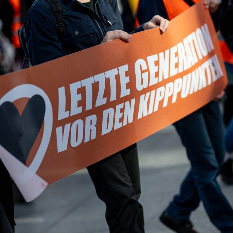 Banner mit der Aufschnitt "Letzte Generation vor den Kipppunkten" (Foto: dpa Bildfunk, Picture Alliance)