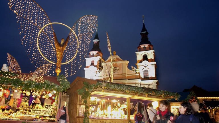Buden auf dem Weihnachtsmarkt in Ludwigsburg mit der Barockkirche im Hintergrund