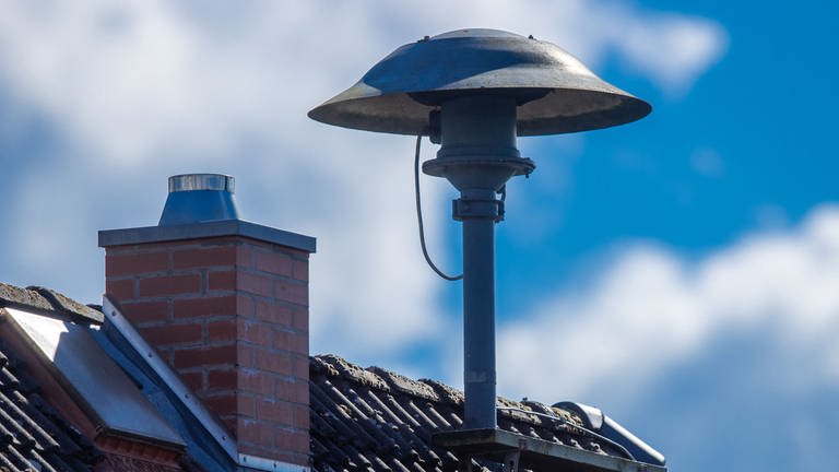 Eine Alarmsirene steht auf einem Hausdach. 