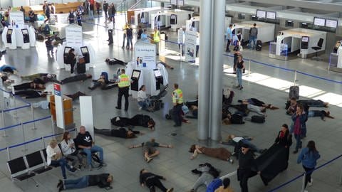Teilnehmer einer Klimaschutz-Demo liegen im Terminal 3 des Stuttgarter Flughafens auf dem Boden.