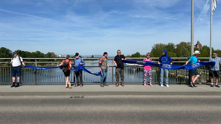 Die Menschenkette führt über den Rhein und ist ein symbolisches Zeichen.
