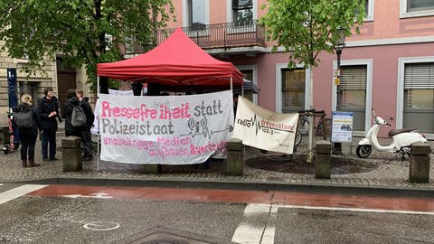 Auf einer Straße steht ein weißer Pavillion - daran Banner mit der Aufschrift "Pressefreiheit" und "Radio Dreyeckland".  (Foto: SWR, Heiner Kunold)