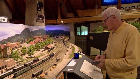 Dieter Bertelsmann blickt auf sein Modell vom Bahnhof Freiburg-Littenweiler.