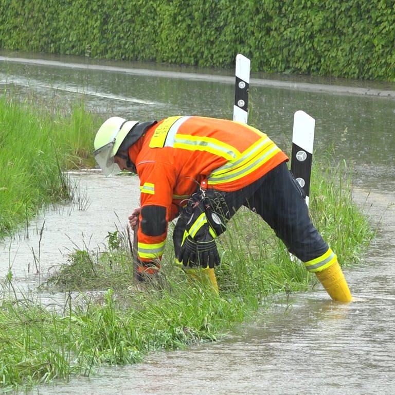 Ein Feuerwehrmann steht auf einer überschwemmten Straße. (Foto: Kamera24)