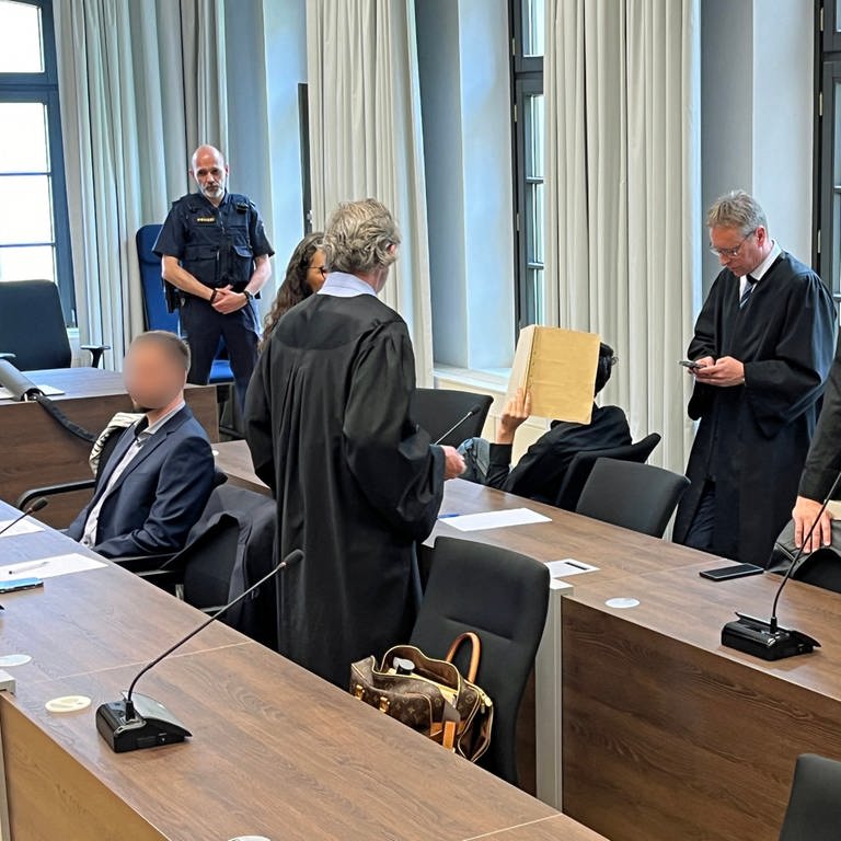Die drei Verurteilten im Prozess zum Doppelmord in Altenstadt umringt von ihren Anwälten. Das Ehepaar bekam jeweils lebenslänglich. Der Mitangeklagte wurde zu einer mehrjährigen Haftstrafe verurteilt.