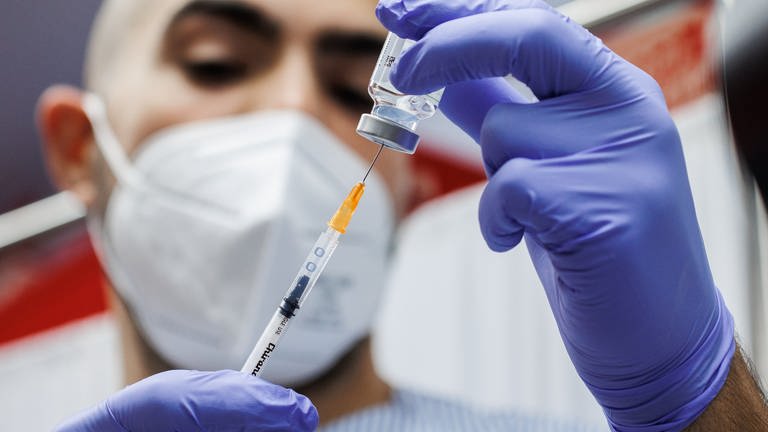 Ein Krankenpfleger bereitet eine Auffrischungsdosis des Corona-Impfstoffs von Moderna vor, der an die Omikron-Sublinie BA.1 angepasst ist.