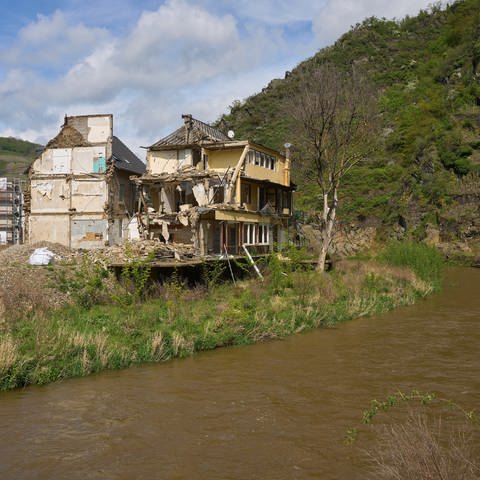 Ein abbruchreifes Haus, das durch die Flutkatastrophe zerstört wurde, steht noch immer am Ufer der Ahr. (Foto: dpa Bildfunk, picture alliance/dpa | Thomas Frey)