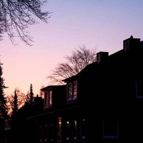 Die Sonne geht am Morgen hinter einem Wohnhaus auf. (Foto: dpa Bildfunk, picture alliance/dpa | Daniel Bockwoldt)