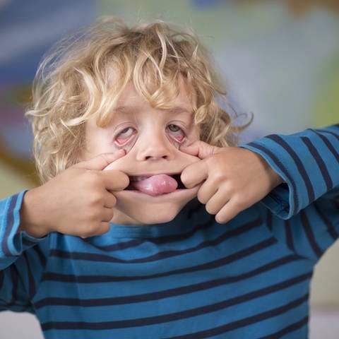 Porträt von einem 6 Jahre alten Jungen, der eine Grimasse macht. (Foto: IMAGO, IMAGO / photothek)